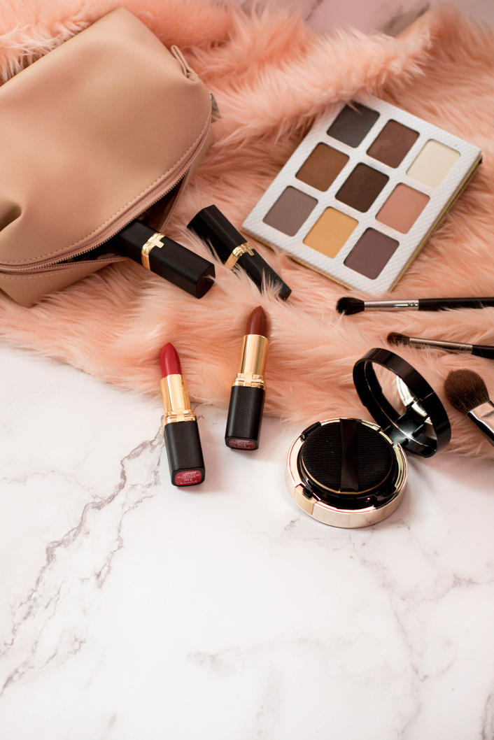 Makeup Kit with Eyeshadow, Brushes, and Lipstick on Fur Carpet